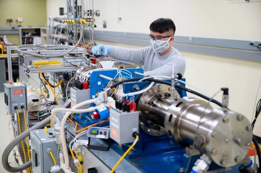 Engineer testing an industrial machine in a lab